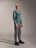 Alpinestars A-Dura Hollow Camo langærmet trøje, Silver Pine Camo, båret af en model med grå bukser og sorte sko, med grønt camouflagemønster og et markant hvidt ASTARS-logo på brystet, højtydende MTB-beklædning