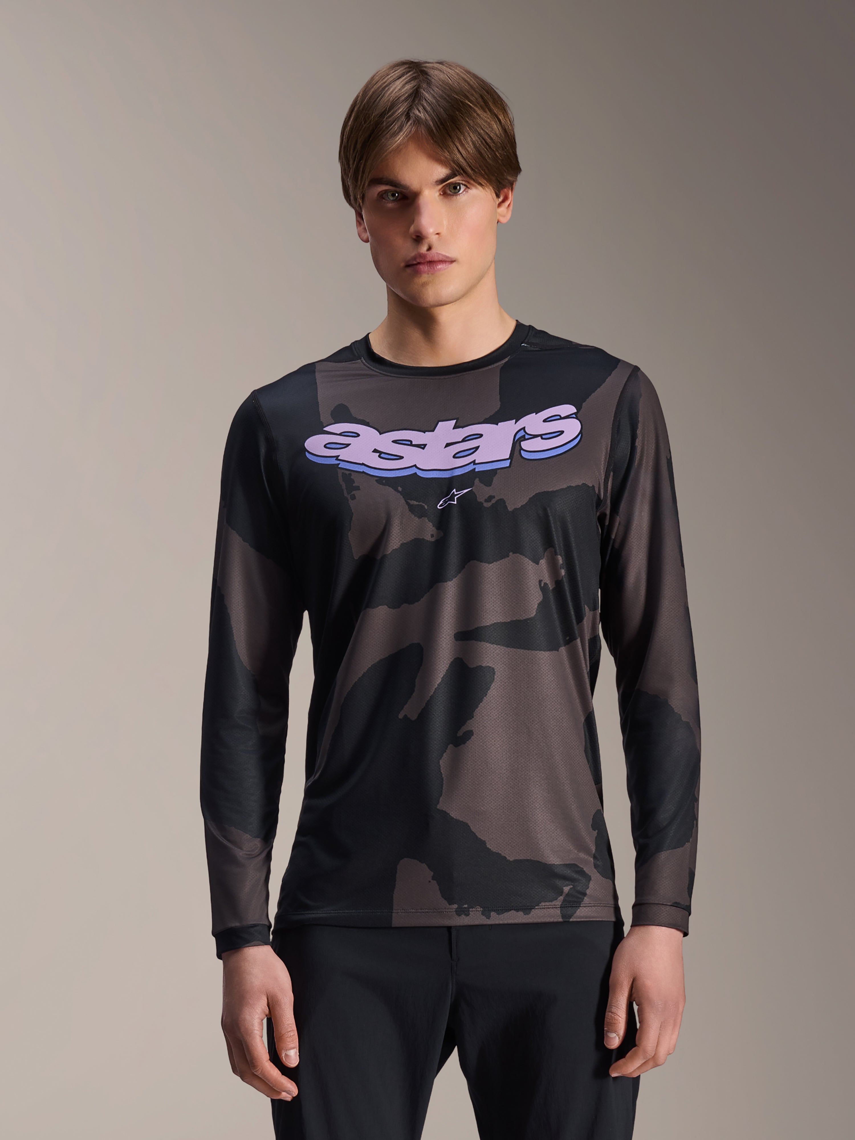 Alpinestars A-Dura Hollow Camo Long Sleeve Jersey, MTB Mountain Bike Jersey, Black and Gray Camouflage Pattern, Purple 'astars' graphic on chest, worn by model with black pants, casual performance design