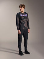 Alpinestars A-Dura Hollow Camo langærmet trøje, sort camouflagemønster med lilla 'astars' grafik på brystet, kombineret med sorte tekniske bukser og sorte sko, afslappet MTB-udstyr