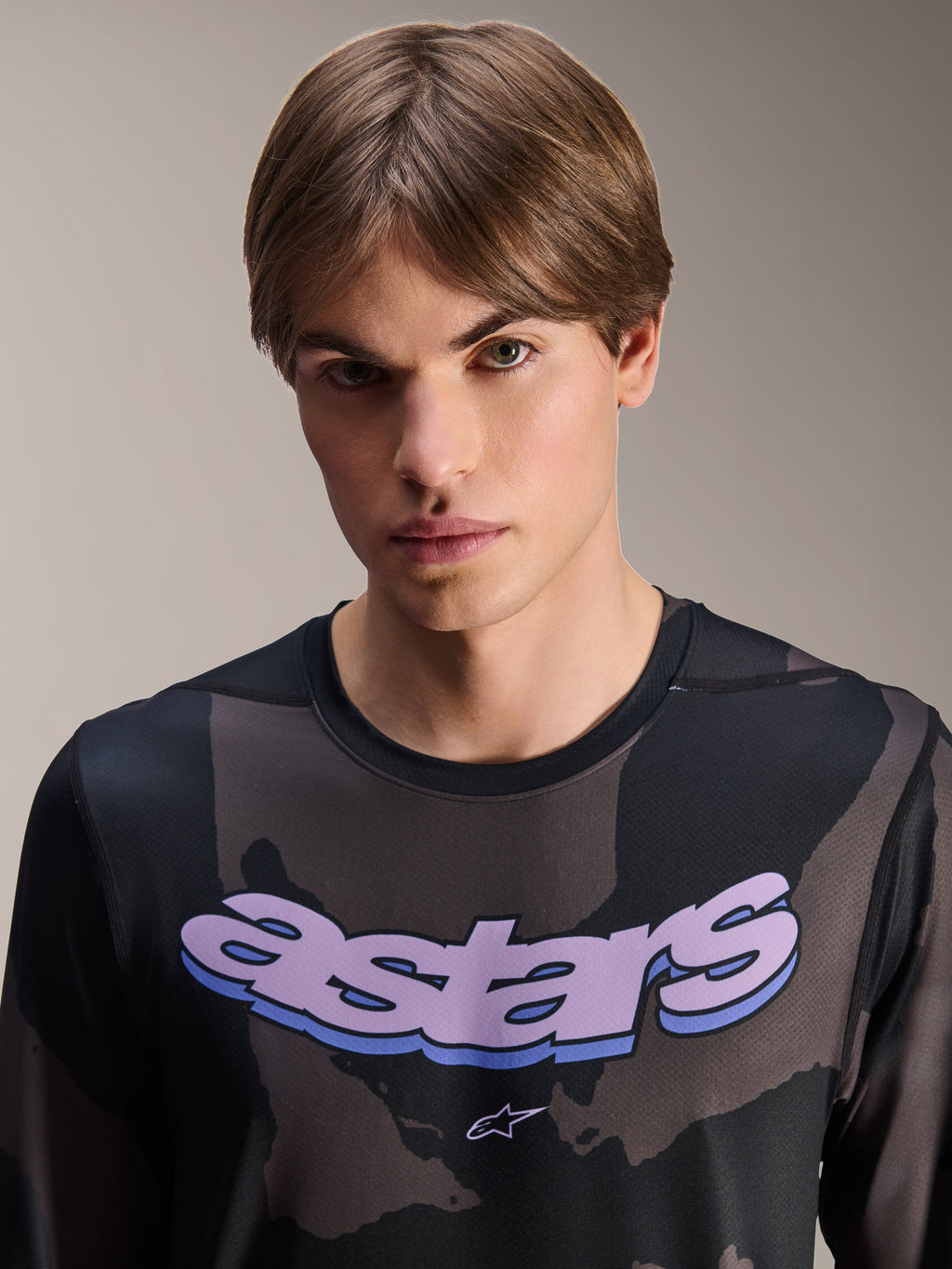 Alpinestars A-Dura Hollow Camo langærmet jersey, Black Camo med lilla 'astars' grafik på brystet, studiobillede af mandlig model i MTB-tøj, afslappet og teknisk mountainbike-stil