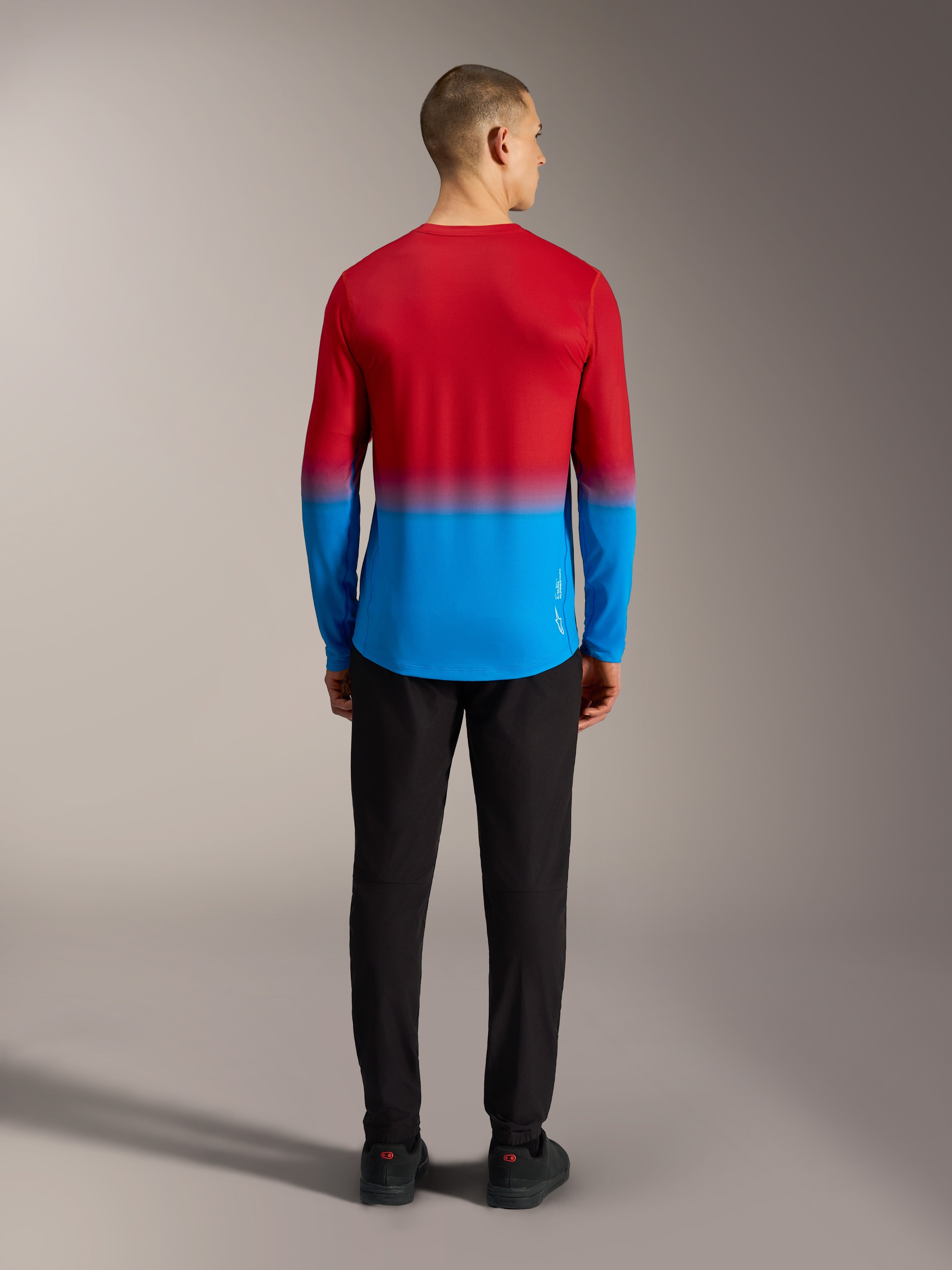 Alpinestars A-Dura ASTARS 2.0 langærmet MTB-jersey i rød og blå gradient, set bagfra på model.