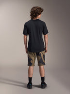 Alpinestars A-Dura Astar kortærmet trøje, sort, set bagfra på en model kombineret med MTB-shorts i camouflagemønster og sort fodtøj, afslappet teknisk mountainbike-beklædning
