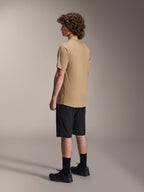 Alpinestars A-Dura Liner Shorts in Black and A-Dura SS Jersey in Tan, worn by a male model from a side profile view, paired with black socks and cycling shoes, mountain bike lifestyle apparel.