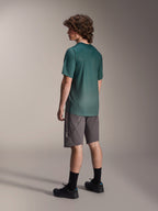 Alpinestars A-Dura Rise Jersey, kortærmet MTB-trøje, Silver Pine Green, båret med grå shorts og sorte sko, set bagfra med længere drop tail og almindelig pasform, letvægts fugttransporterende materiale til trailkørsel