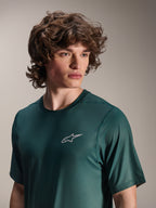 Alpinestars A-Dura Rise Jersey - kortærmet, Silver Pine grøn, båret af en model, lille hvidt Astars-logo på brystet, jacquard performance-stof, afslappet mountainbike-beklædning