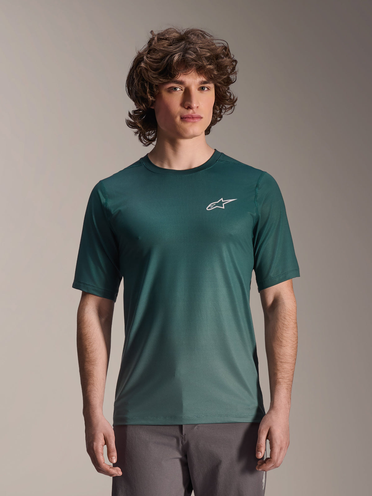 Alpinestars A-Dura Rise trøje - kortærmet, Silver Pine mørkegrøn, båret af en model, med hvidt Astars-logo på brystet, letvægts jacquard-stof med fugttransport, afslappet mountainbike-performance-trøje