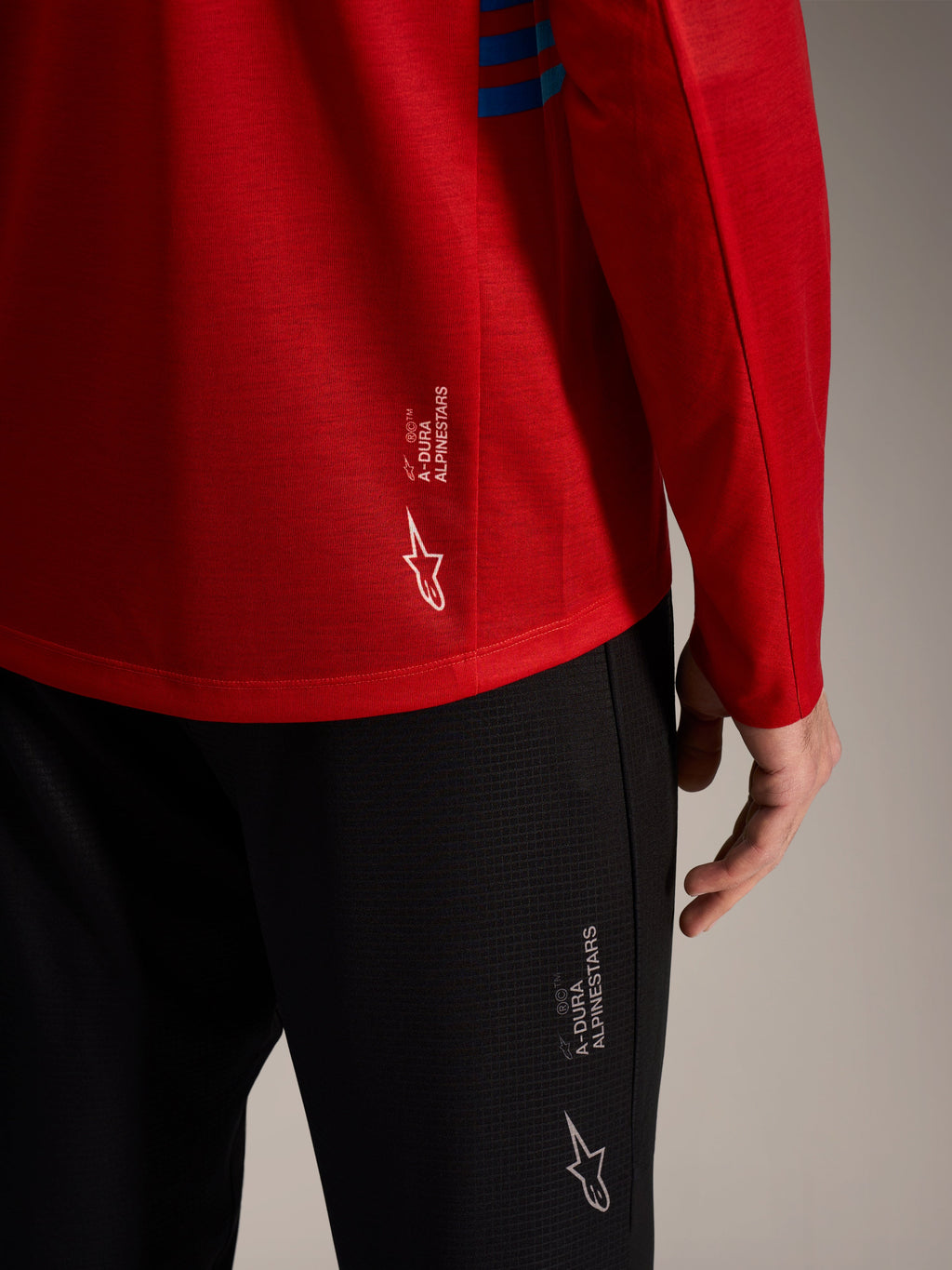 Rød A-Dura Elite langærmet trøje 2.0 og sorte MTB-bukser med Alpinestars-logoer og performance-stof.