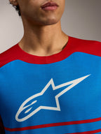 Alpinestars A-Dura Elite Trøje 2.0, blå og rød MTB-trøje med hvidt stjerne-logo på brystet, i let og åndbart materiale.