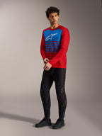 Rød Alpinestars A-Dura Elite 2.0 langærmet trøje med blåt stribet brystpanel, hvidt logo og sorte MTB-bukser.