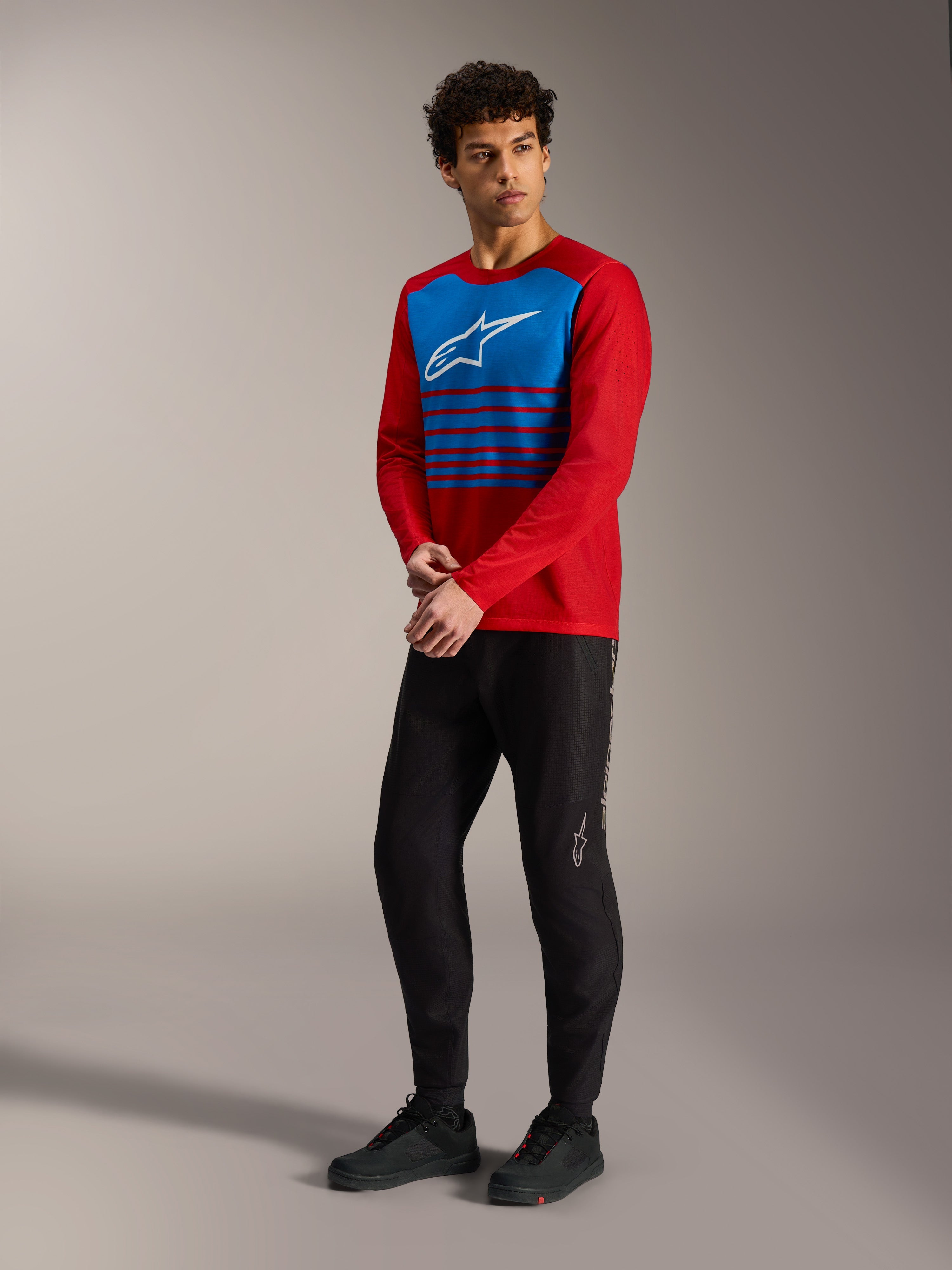 Rød Alpinestars A-Dura Elite 2.0 langærmet trøje med blåt stribet brystpanel, hvidt logo og sorte MTB-bukser.