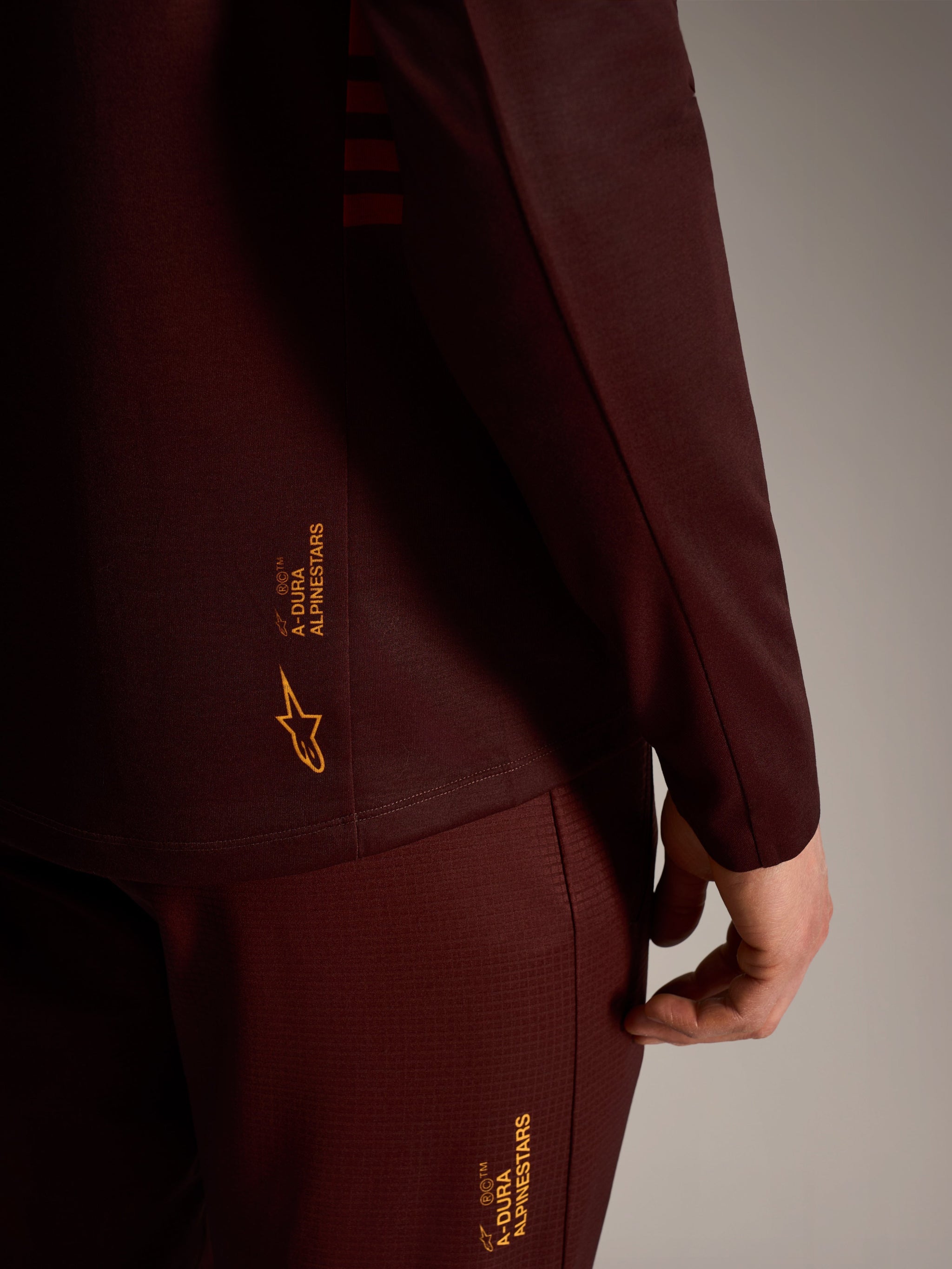 A-Dura Elite langærmet trøje i bordeaux med gult Alpinestars-branding, teknisk trail-udstyr.