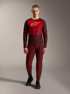 Alpinestars A-Dura Elite Jersey 2.0, langærmet MTB-trøje i bordeaux med gult brystlogo og røde striber.