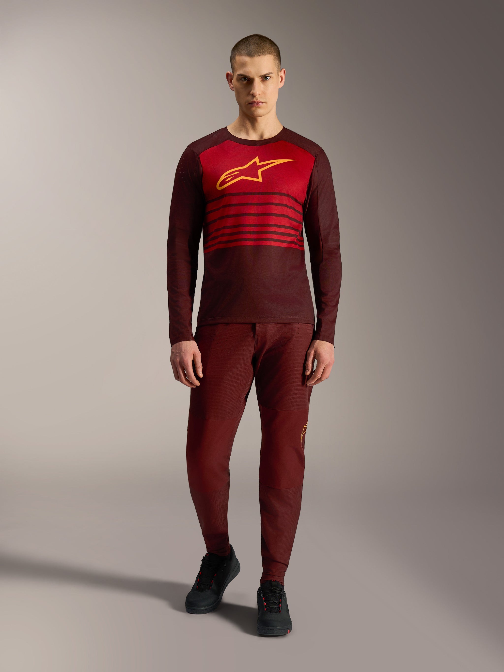 Alpinestars A-Dura Elite Jersey 2.0, langærmet MTB-trøje i bordeaux med gult brystlogo og røde striber.
