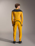 Alpinestars Limited Edition A-Supra Melt Gold-udstyrssæt, model set bagfra, mørkegul langærmet trøje med sort skulderstykke, mørkegule bukser med et stort sort Alpinestars-ordmærke over bagstykket, kombineret med sorte sko.