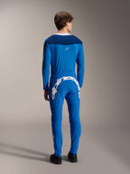 Mandlig model set bagfra iført Alpinestars A-Supra Melt langærmet trøje i blå, kombineret med matchende blå præstationsbukser med et stort hvidt Alpinestars-logo hen over ryggen, komplet MTB-racerkit