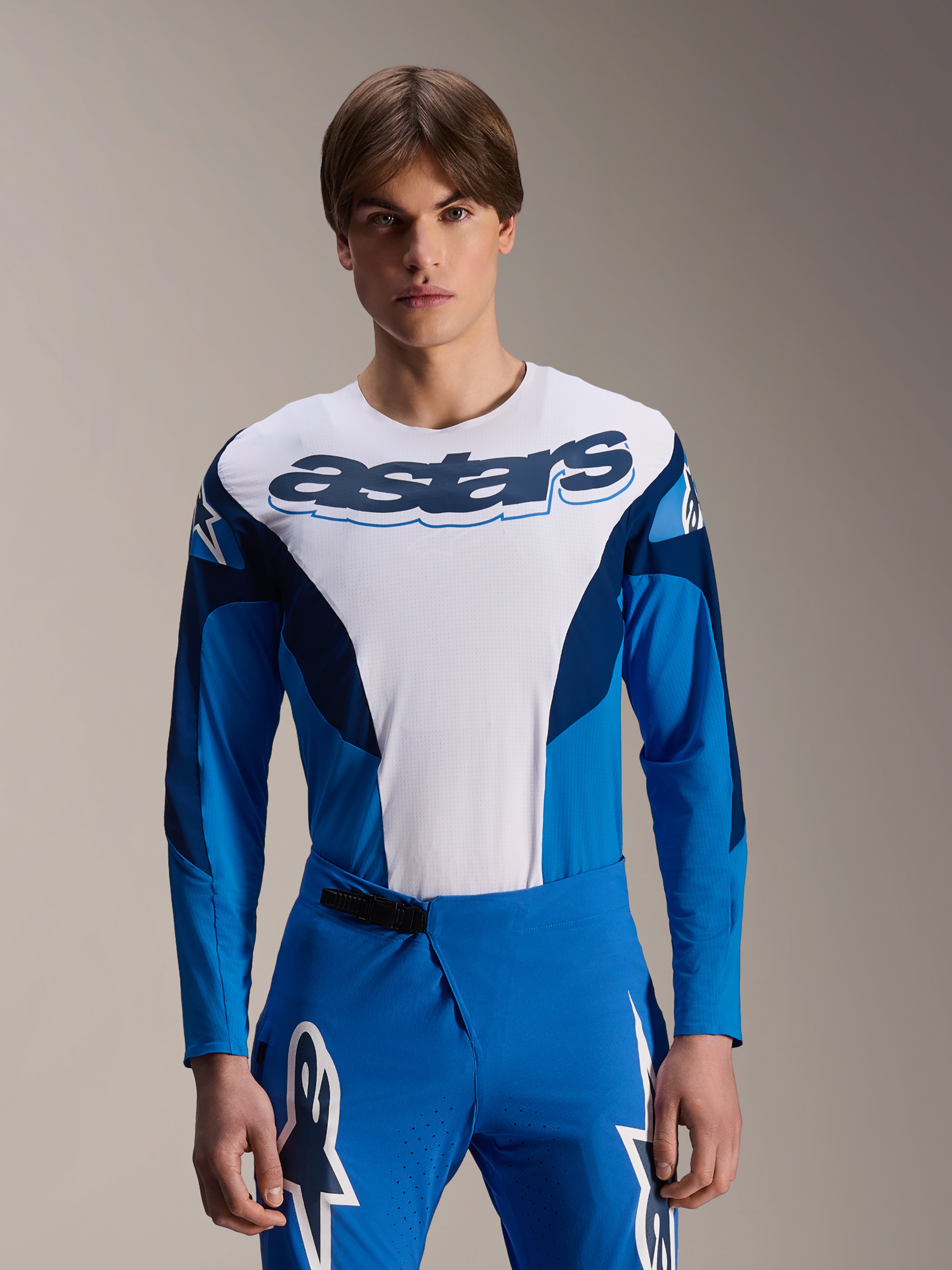 Alpinestars A-Supra Melt langærmet trøje, blå og hvid MTB-trøje med markant astars-branding over brystet, mørkeblå ærmer, båret med matchende blå racerbukser med hvide stjernelogoer, performance mountainbike-beklædning