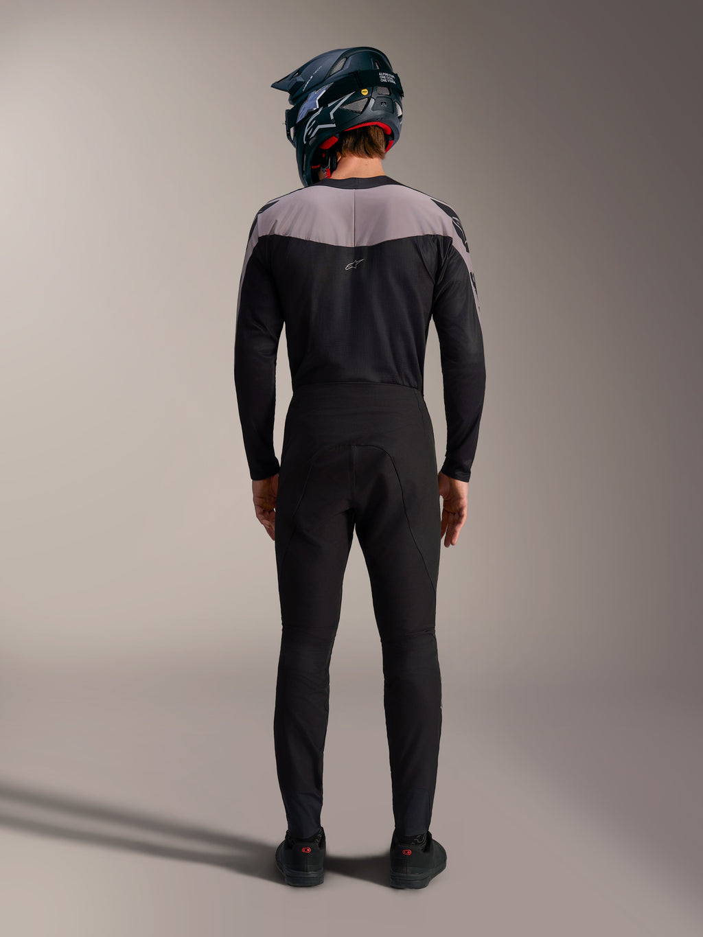 Alpinestars A-Supra Elite MTB-sæt i sort med bukser, trøje og full-face hjelm, set bagfra.