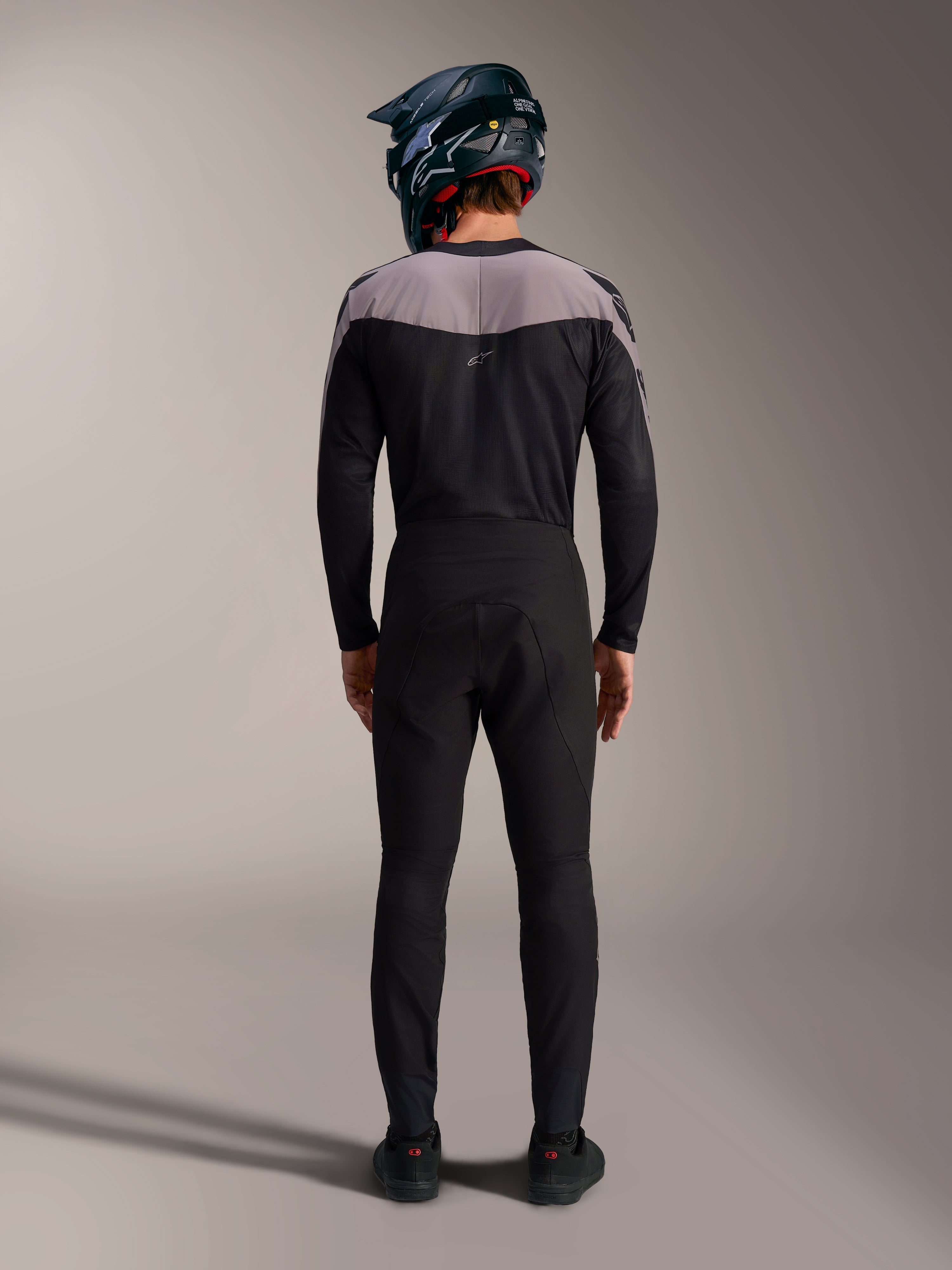 Alpinestars A-Supra Elite MTB-sæt i sort med bukser, trøje og full-face hjelm, set bagfra.