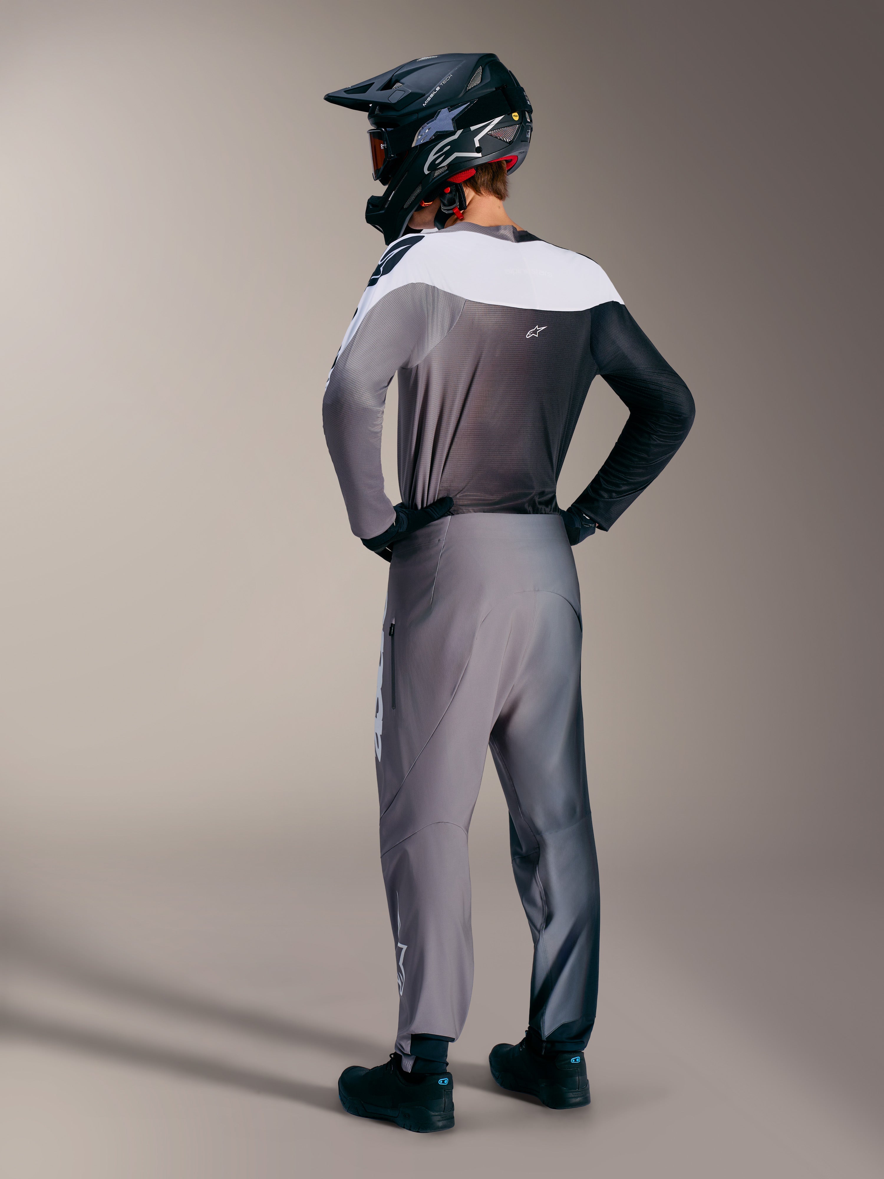 Alpinestars A-Supra Elite trøje i Faded Gray, set bagfra i et MTB-sæt med gradientfarver og performance-pasform.