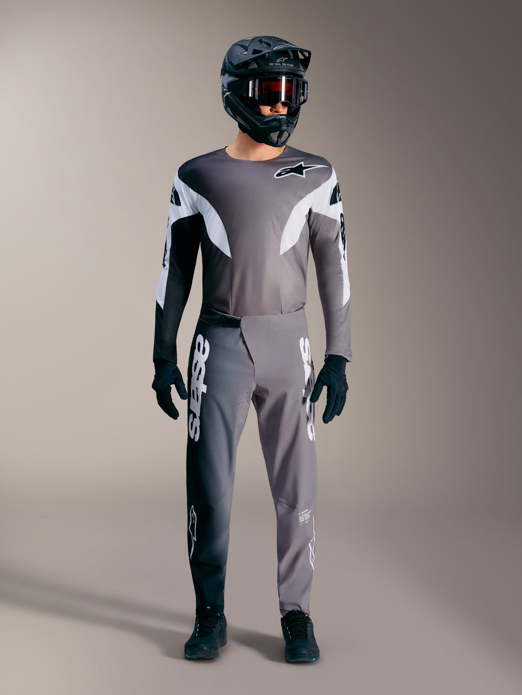 Alpinestars A-Supra Elite MTB-udstyr i falmet grå, med performance-trøje og bukser med markante hvide logoer.