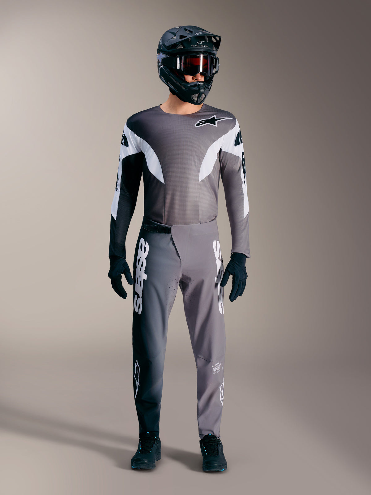 Alpinestars A-Supra Elite MTB-udstyr i falmet grå, med performance-trøje og bukser med markante hvide logoer.
