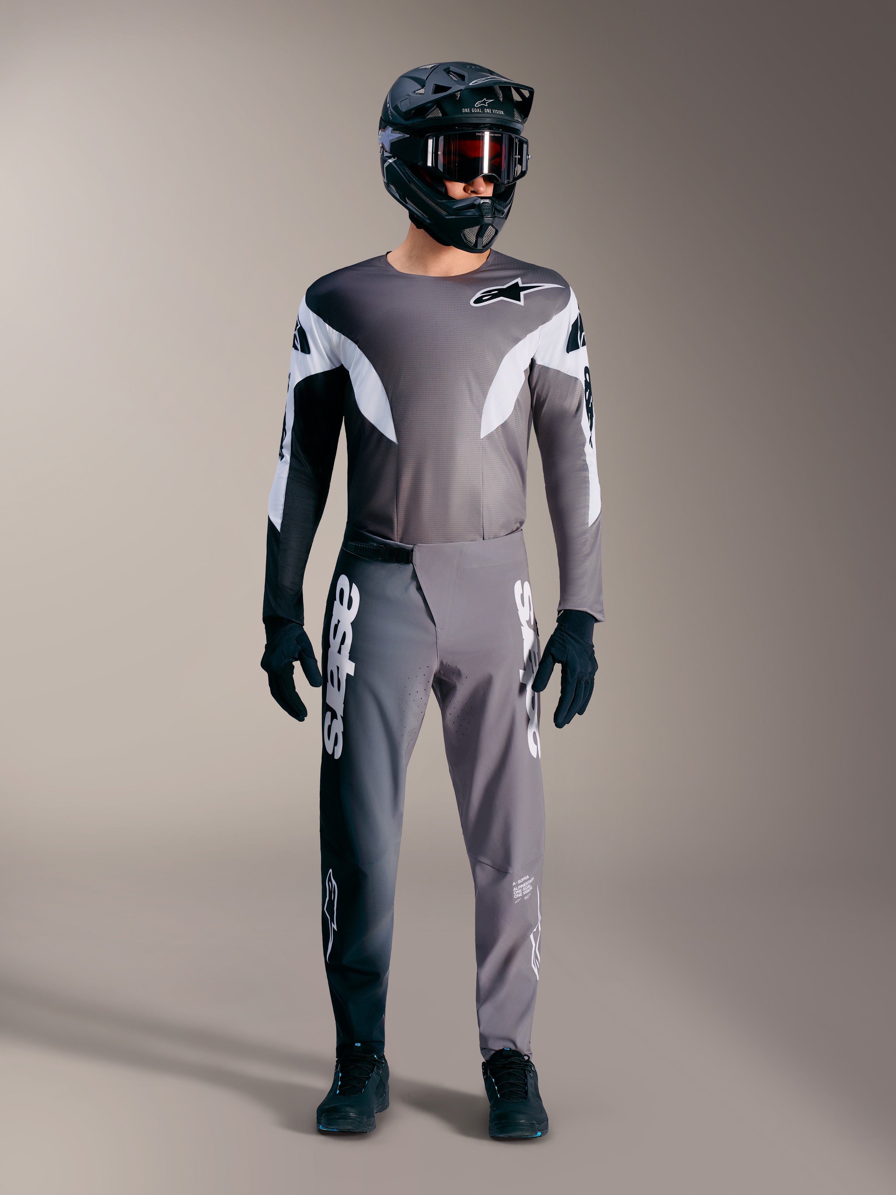 Alpinestars A-Supra Elite MTB-udstyr i falmet grå, med performance-trøje og bukser med markante hvide logoer.