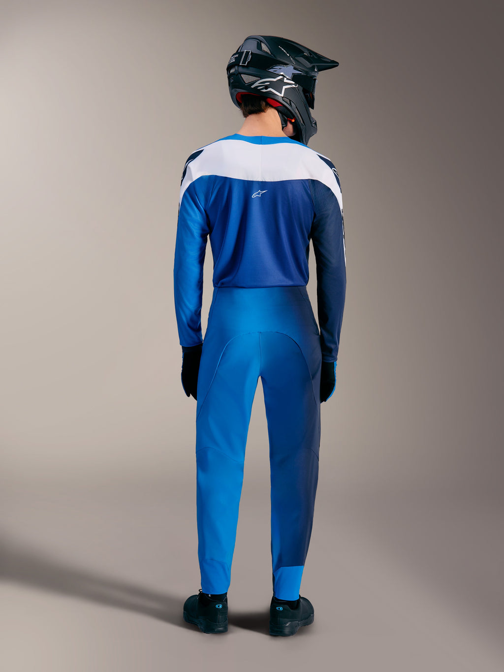 A-Supra Elite MTB-sæt i Faded Bright Blue, bagfra med gradient trøje og performancebukser med hvide paneler.