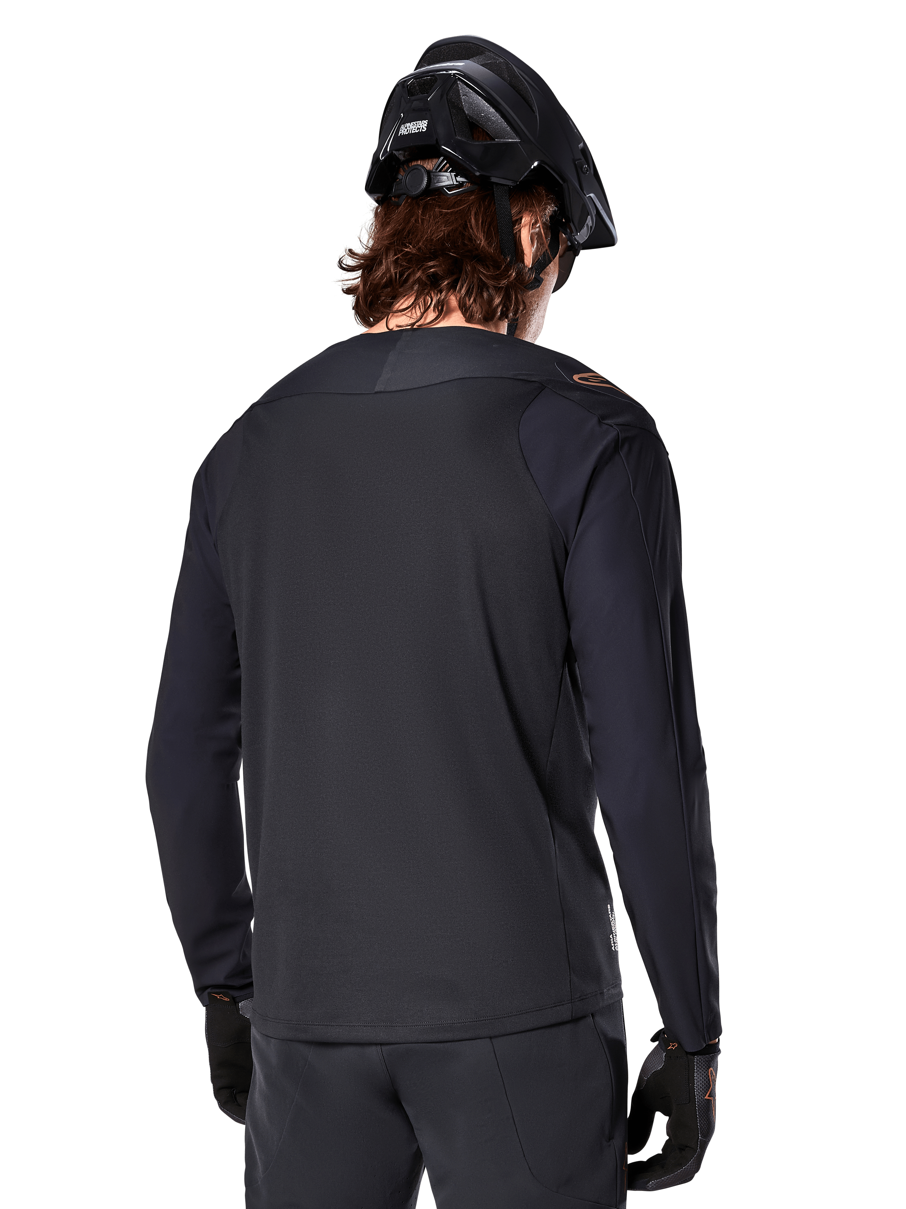 Alpinestars A-Aria Polartec Switch langærmet trøje, sort, set bagfra, båret med en sort MTB-hjelm og handsker, med drop tail-design til off-road ydeevne