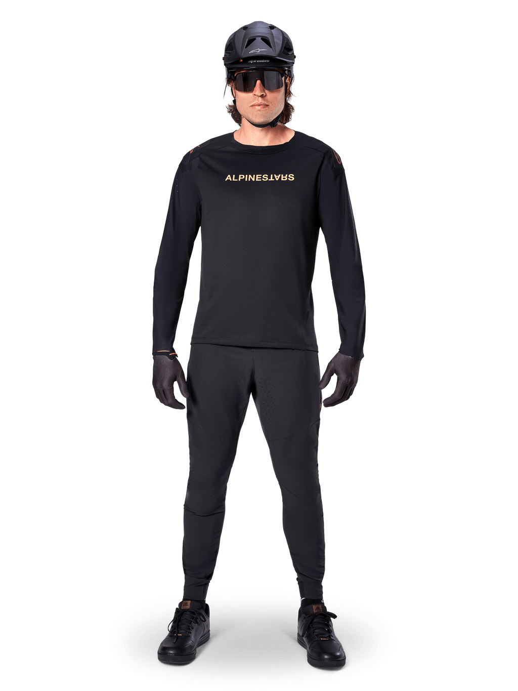 Alpinestars A-Aria Polartec Switch langærmet jersey, sort, båret af en rytter med matchende sorte tekniske bukser, sort hjelm, solbriller og sorte handsker, performance MTB-udstyr til terrænkørsel