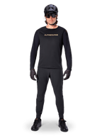 Alpinestars A-Aria Polartec Switch langærmet jersey, sort, båret af en rytter med matchende sorte tekniske bukser, sort hjelm, solbriller og sorte handsker, performance MTB-udstyr til terrænkørsel