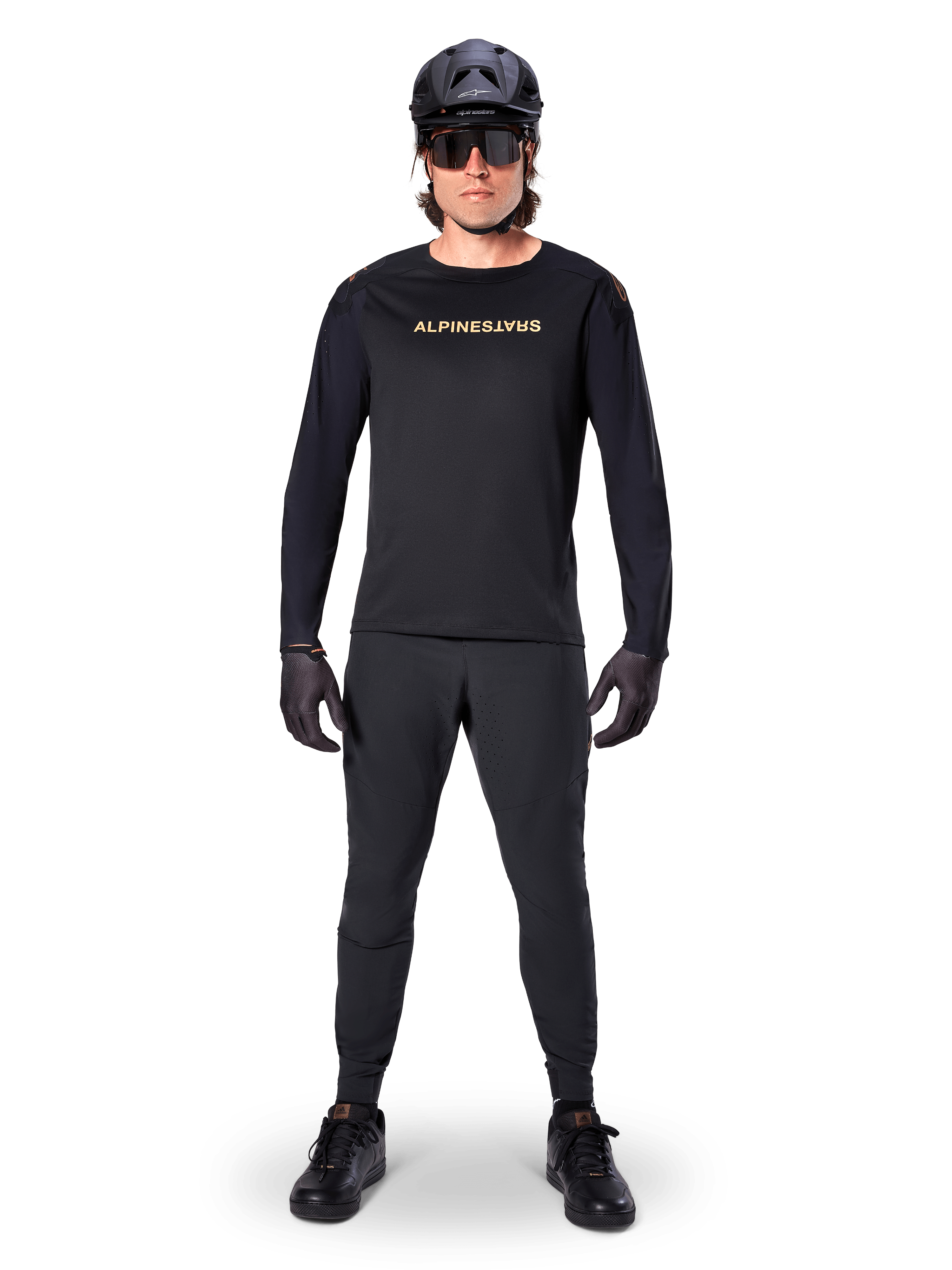 Alpinestars A-Aria Polartec Switch langærmet jersey, sort, båret af en rytter med matchende sorte tekniske bukser, sort hjelm, solbriller og sorte handsker, performance MTB-udstyr til terrænkørsel