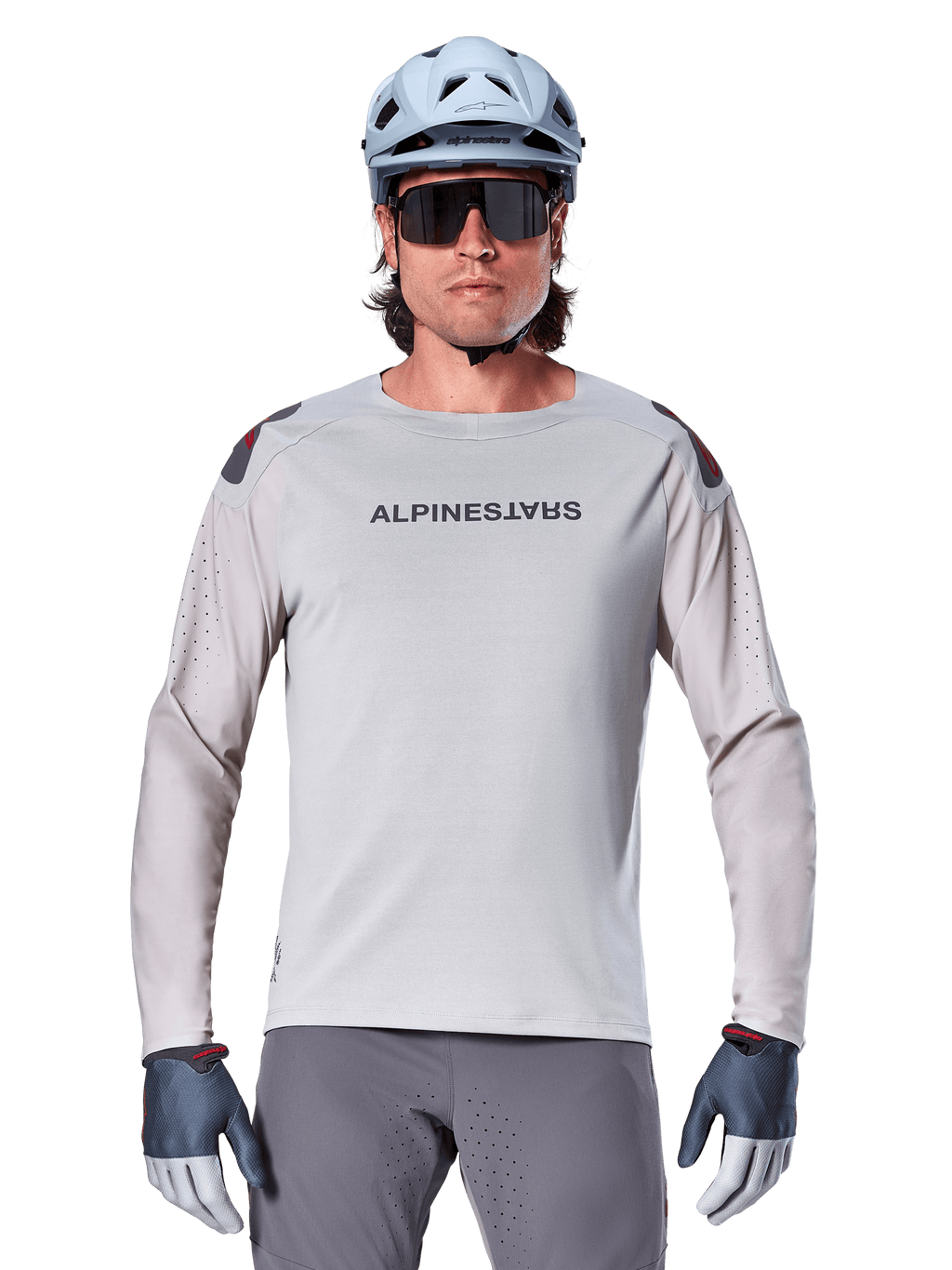 Alpinestars A-Aria Polartec Switch langærmet jersey, lysegrå mountainbike-jersey med laserperforeringer på ærmerne og brandnavn på brystet, båret med lyseblå hjelm, solbriller og grå handsker