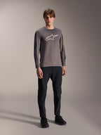 Alpinestars A-Dura Insert Astar trøje, langærmet MTB-trøje, mørkegrå, med stort hvidt brystlogo, båret med sorte tekniske bukser og sorte sko, off-road cykeludstyr