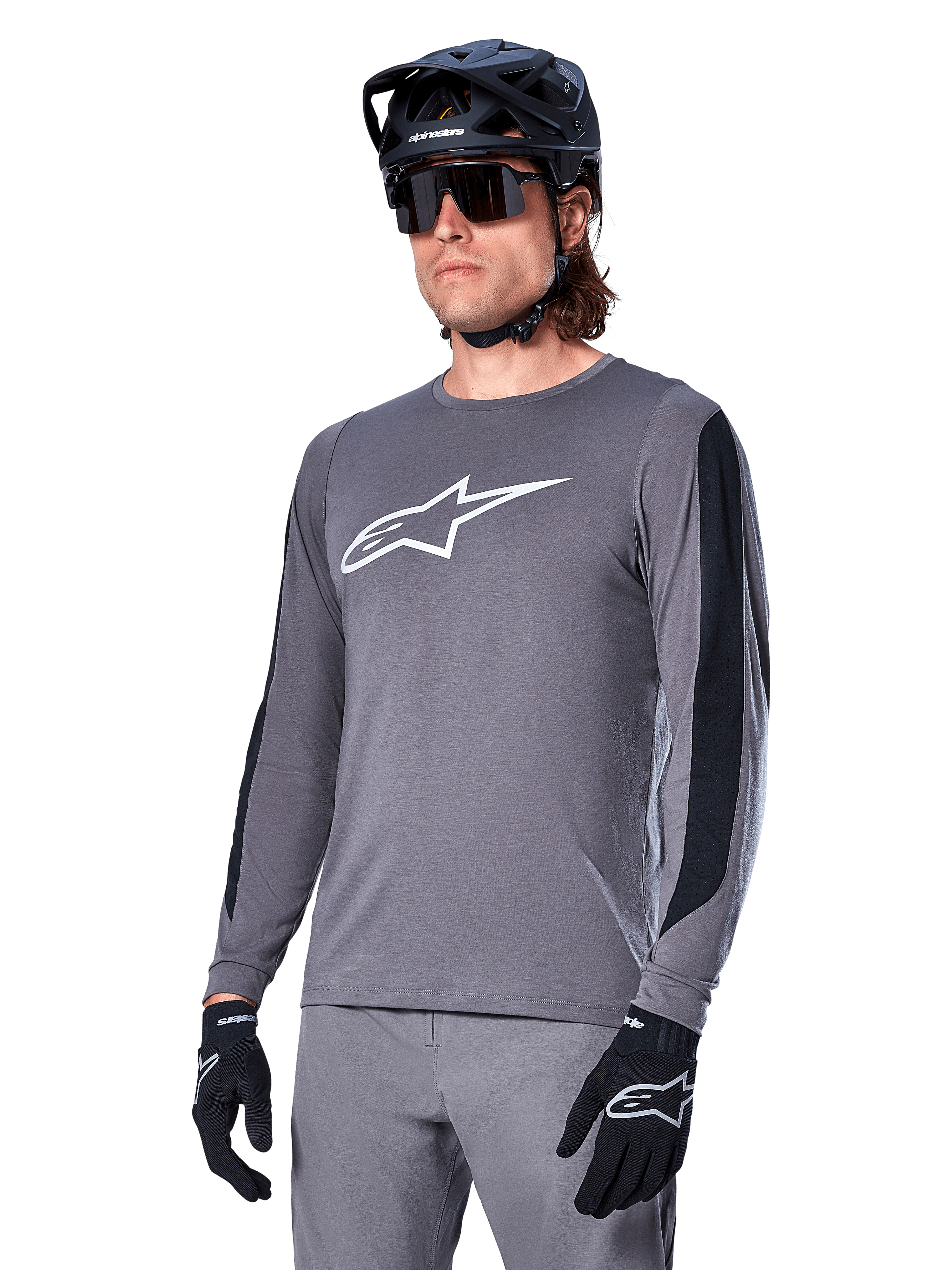 Alpinestars A-Dura Dri Astar langærmet jersey, mørkegrå med hvidt brystlogo og sorte mesh-sidepaneler, MTB mountainbike-trøje, vist med sort hjelm, solbriller og matchende grå bukser
