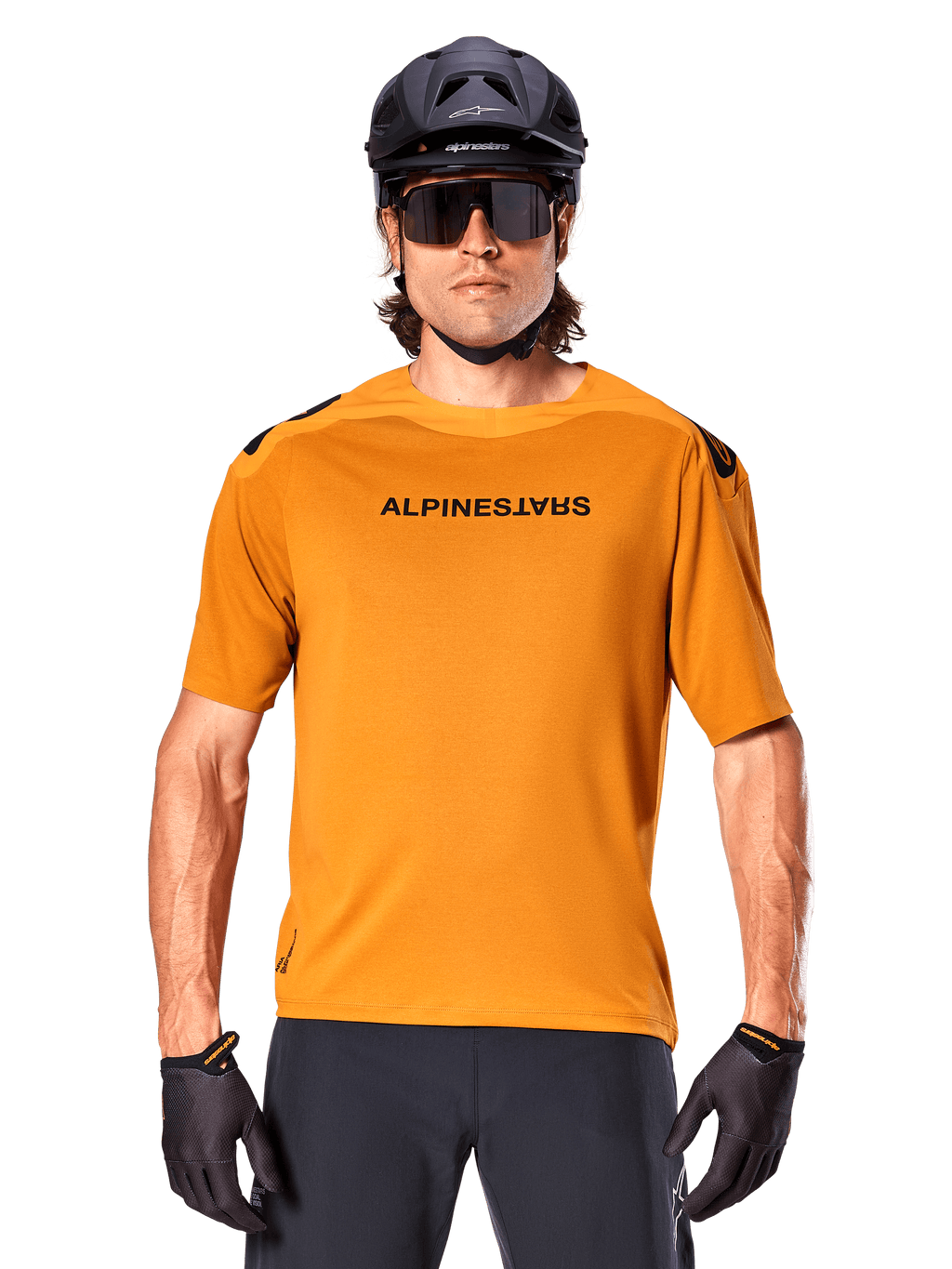 Alpinestars A-Aria Polartec Switch trøje, kortærmet, mørk guld, mountainbikerytter iført sort hjelm og solbriller, performance cykeltøj til MTB-spor