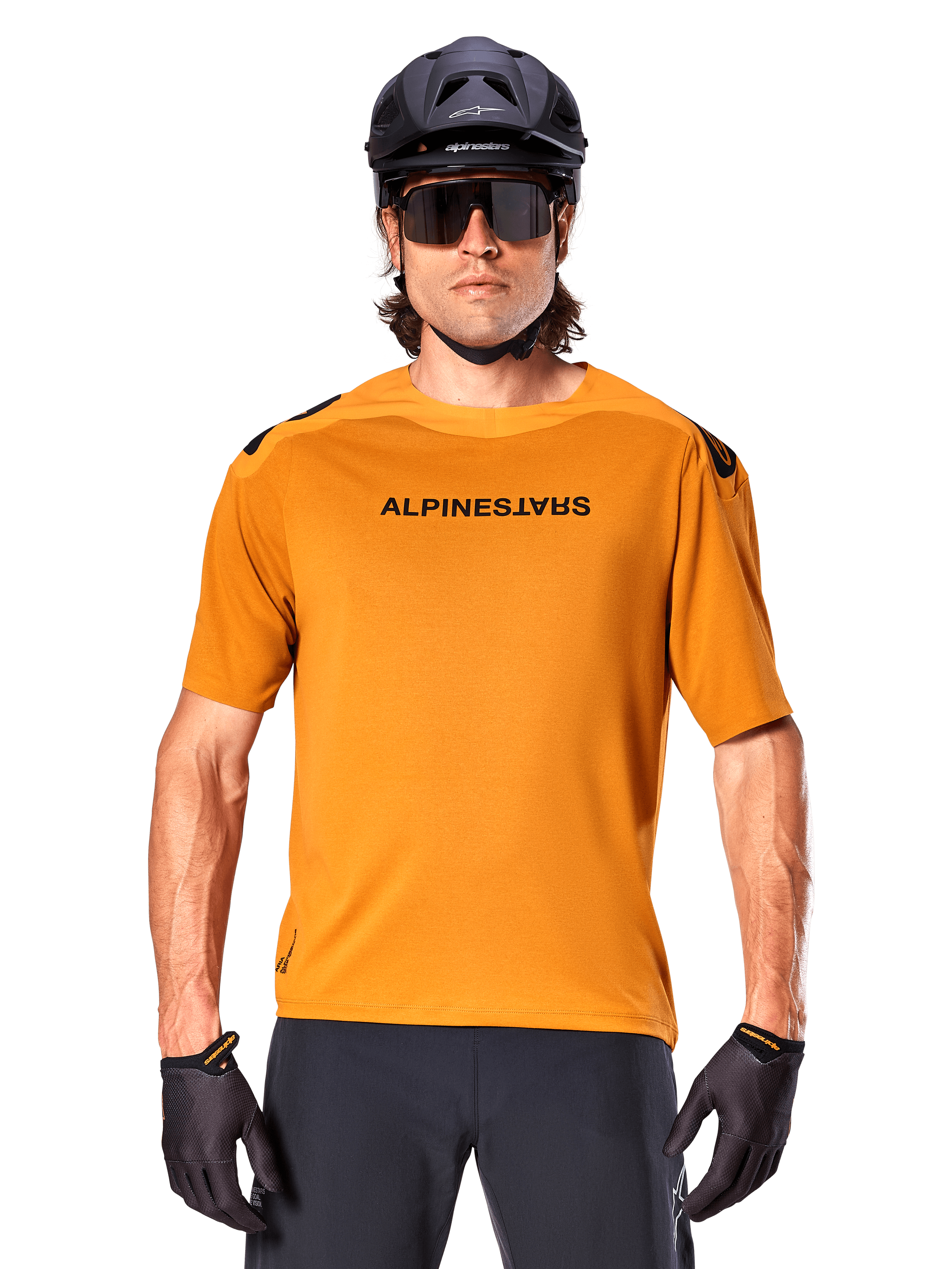 Alpinestars A-Aria Polartec Switch trøje, kortærmet, mørk guld, mountainbikerytter iført sort hjelm og solbriller, performance cykeltøj til MTB-spor