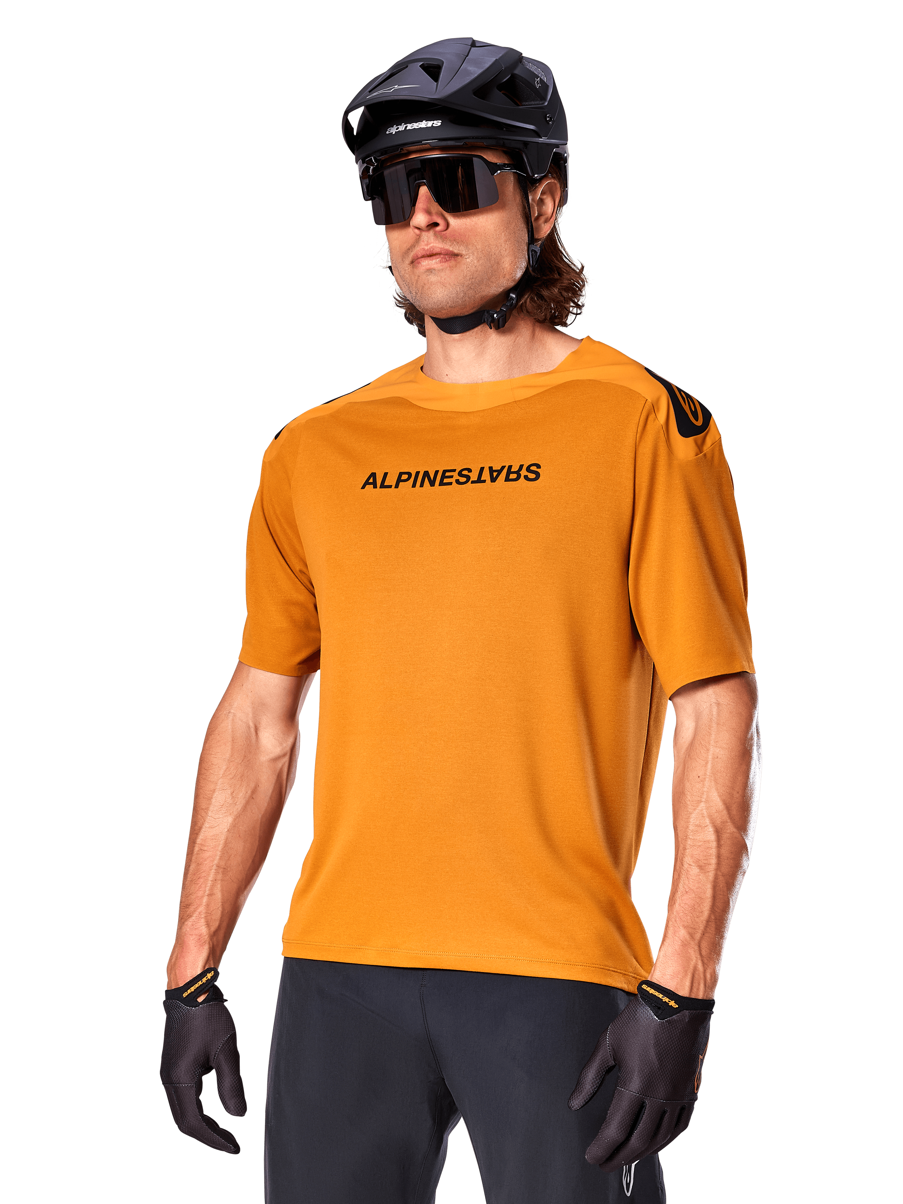 Alpinestars A-Aria Polartec Switch Jersey, Short Sleeve MTB Jersey, Dark Gold with black branding, worn by model with black helmet, sunglasses, and cycling gloves, high-performance mountain bike apparel
