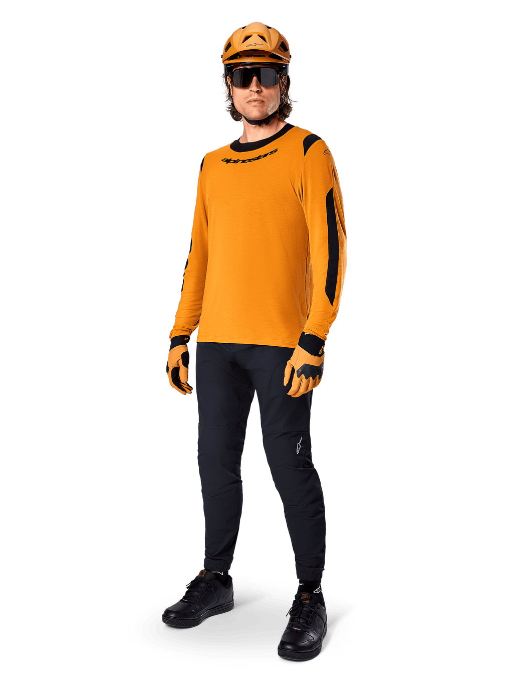 Alpinestars A-Dura Dri Wool Jersey - langærmet, Dark Gold, båret med matchende orange hjelm, sorte MTB-bukser og gul-sorte handsker, komplet cykeloutfit til terrænkørsel