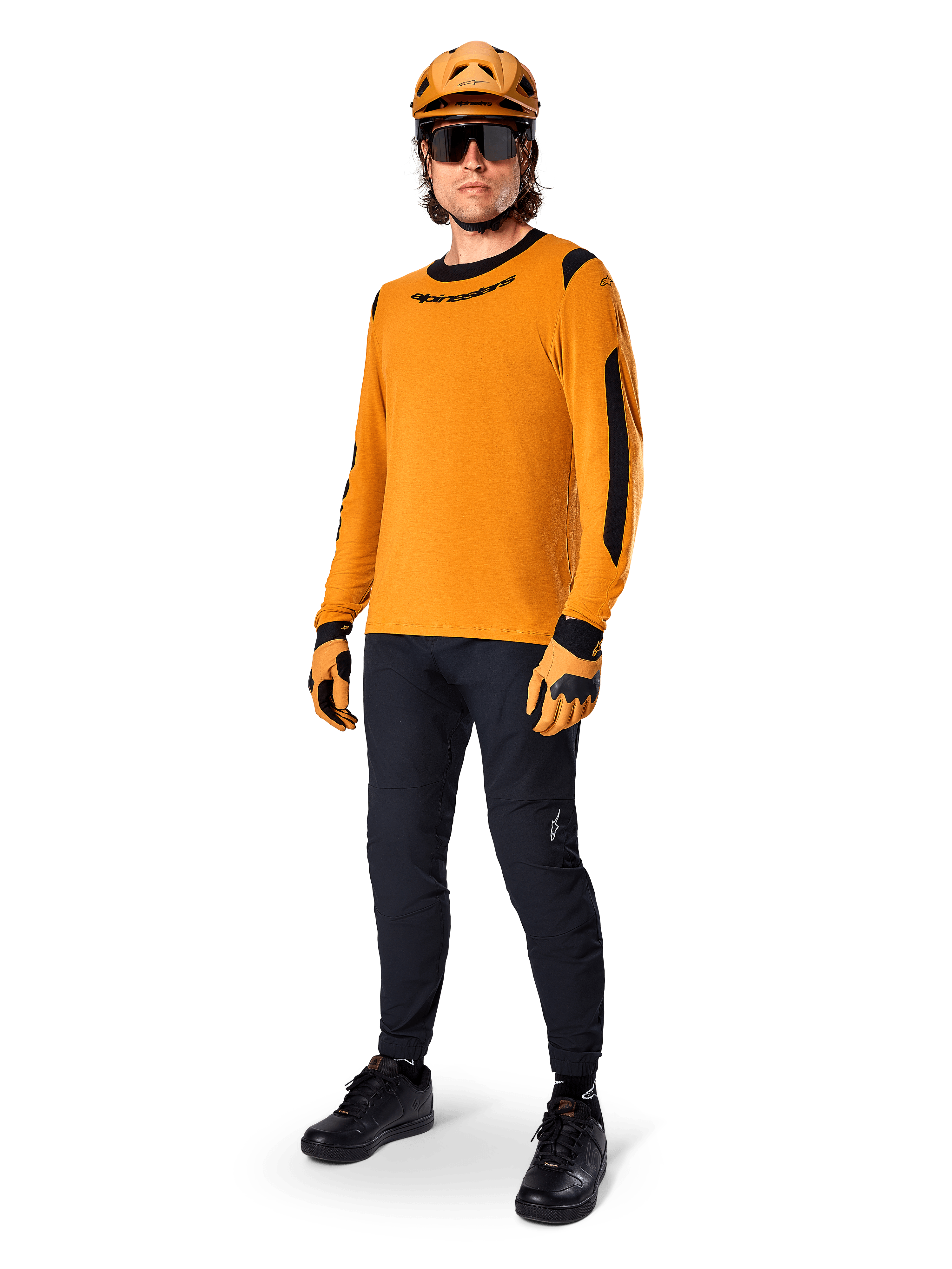 Alpinestars A-Dura Dri Wool Jersey - langærmet, Dark Gold, båret med matchende orange hjelm, sorte MTB-bukser og gul-sorte handsker, komplet cykeloutfit til terrænkørsel