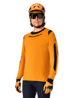 Alpinestars A-Dura Dri Wool Jersey - langærmet trøje, MTB-cykeltrøje, mørk guld og sort, med fugtafledende merinouldblanding og mesh-paneler, rytter iført matchende hjelm, solbriller og handsker