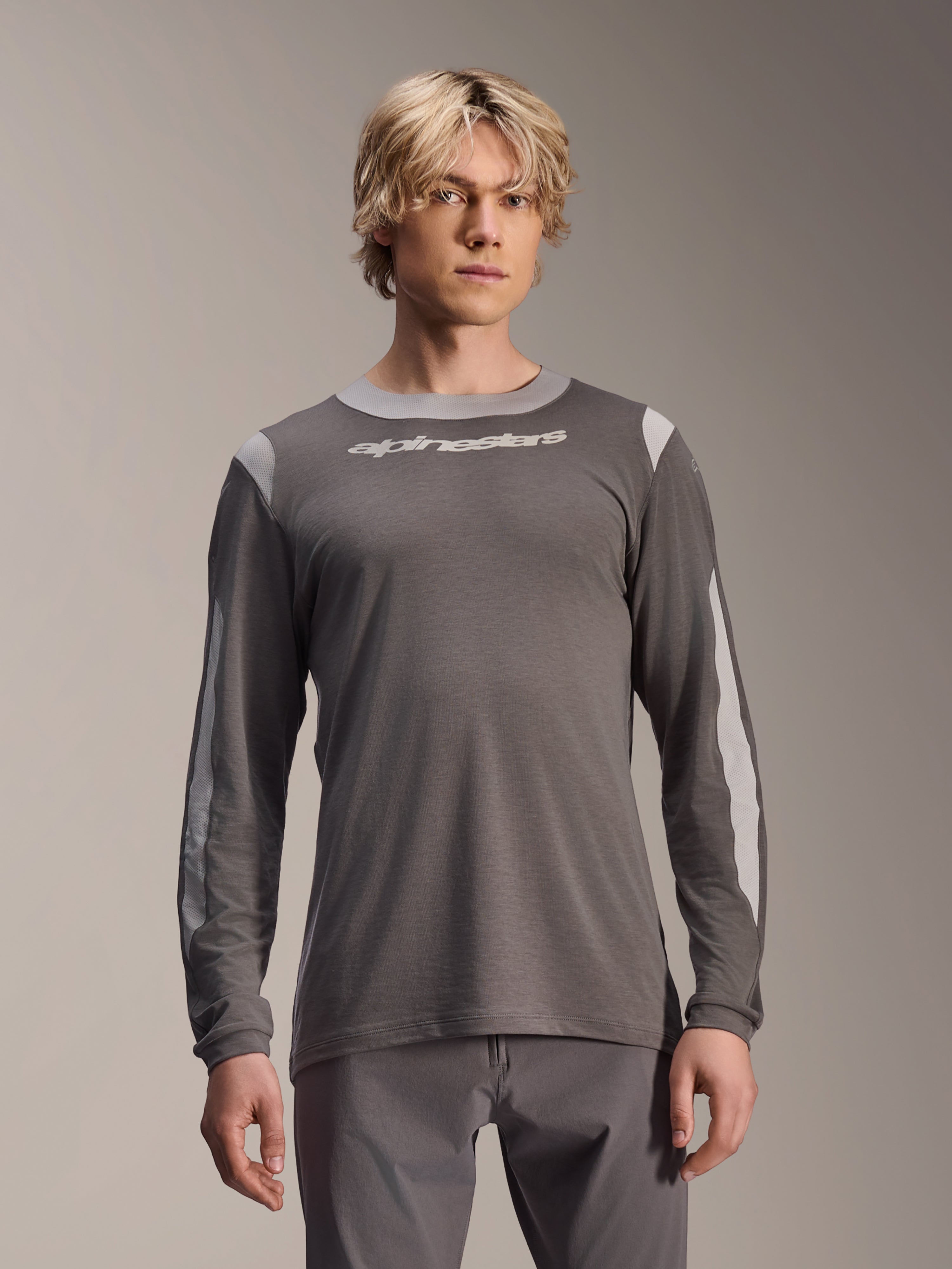 Alpinestars A-Dura Dri Wool Jersey Long Sleeve, Dark Gray, worn by male model, featuring light gray mesh panels on shoulders and sleeves, white wordmark logo on chest, performance mountain bike gear