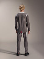 Alpinestars A-Dura Dri Wool Jersey - langærmet, mørkegrå, set bagfra på model, med lysegrå mesh-paneler på skuldre og krave, forlænget rygkant med lille rødt mærke, båret med matchende grå cykelbukser.