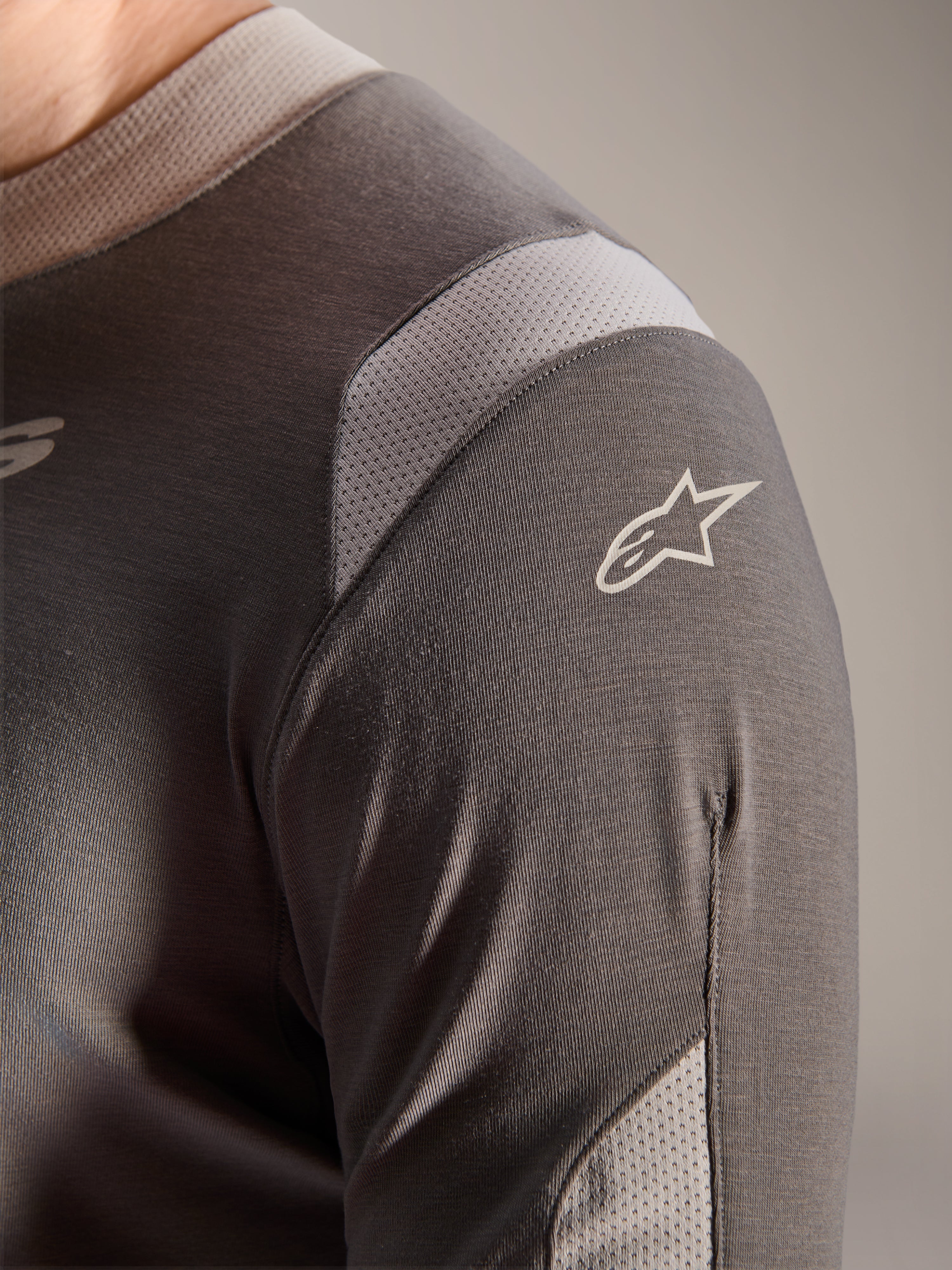 Alpinestars A-Dura Dri Wool langærmet trøje, mørkegrå, detaljeret visning af skulder og ærme, lysegrå mesh-ventilationspaneler, hvidt Astars-logo, teknisk drirelease-stof