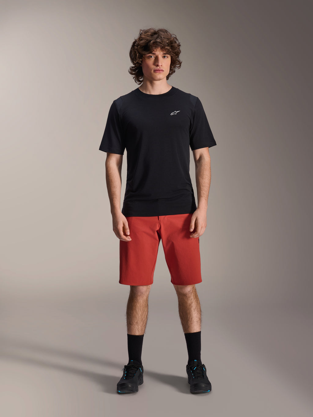 Alpinestars A-Dura Elite Shorts, MTB mountainbike-shorts, mørk orange, båret med en sort kortærmet jersey og cykelsko, højtydende cykeltøj til mountainbiking