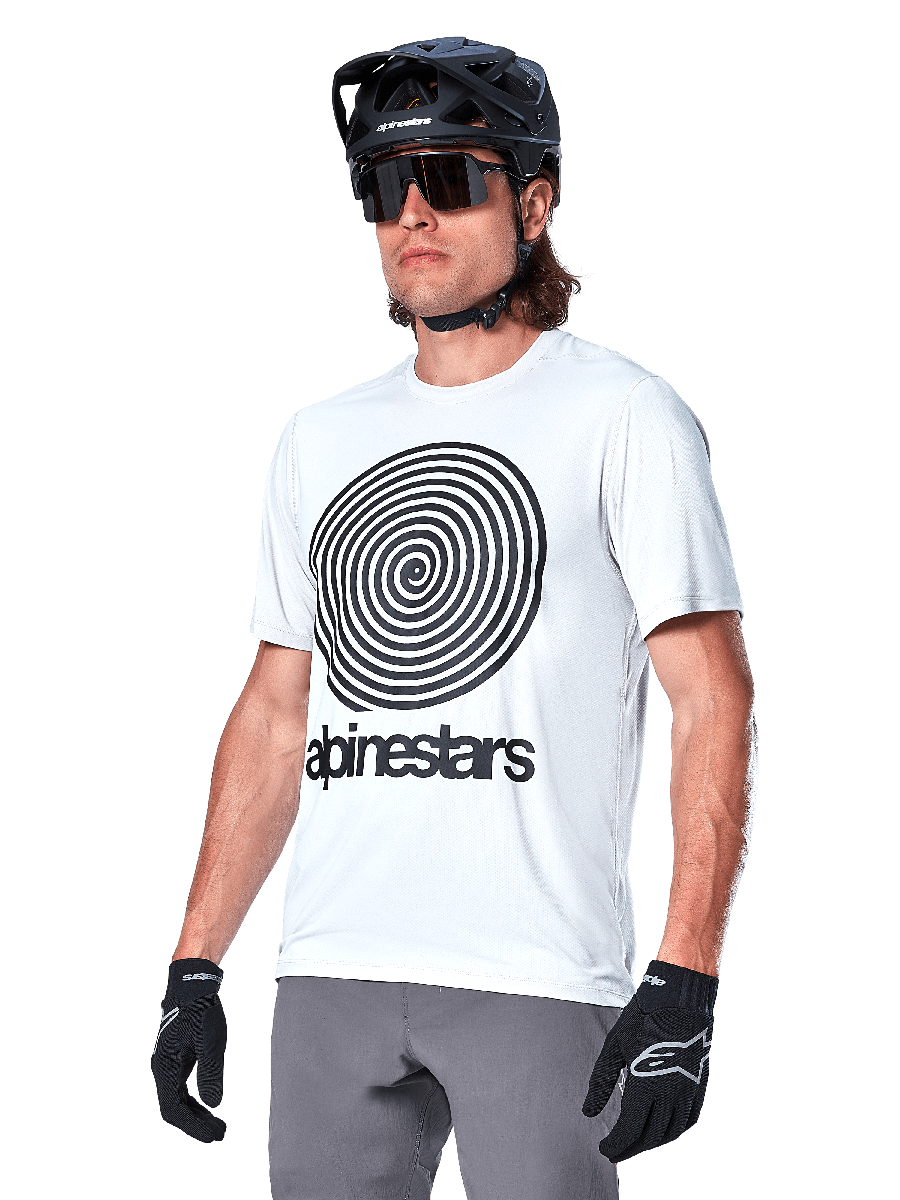 Alpinestars A-Dura Oscar trøje - kortærmet, White Dove med sort heritage-spiralgrafik og logo, båret med sort MTB-hjelm og handsker, sporty performance mountainbike-beklædning