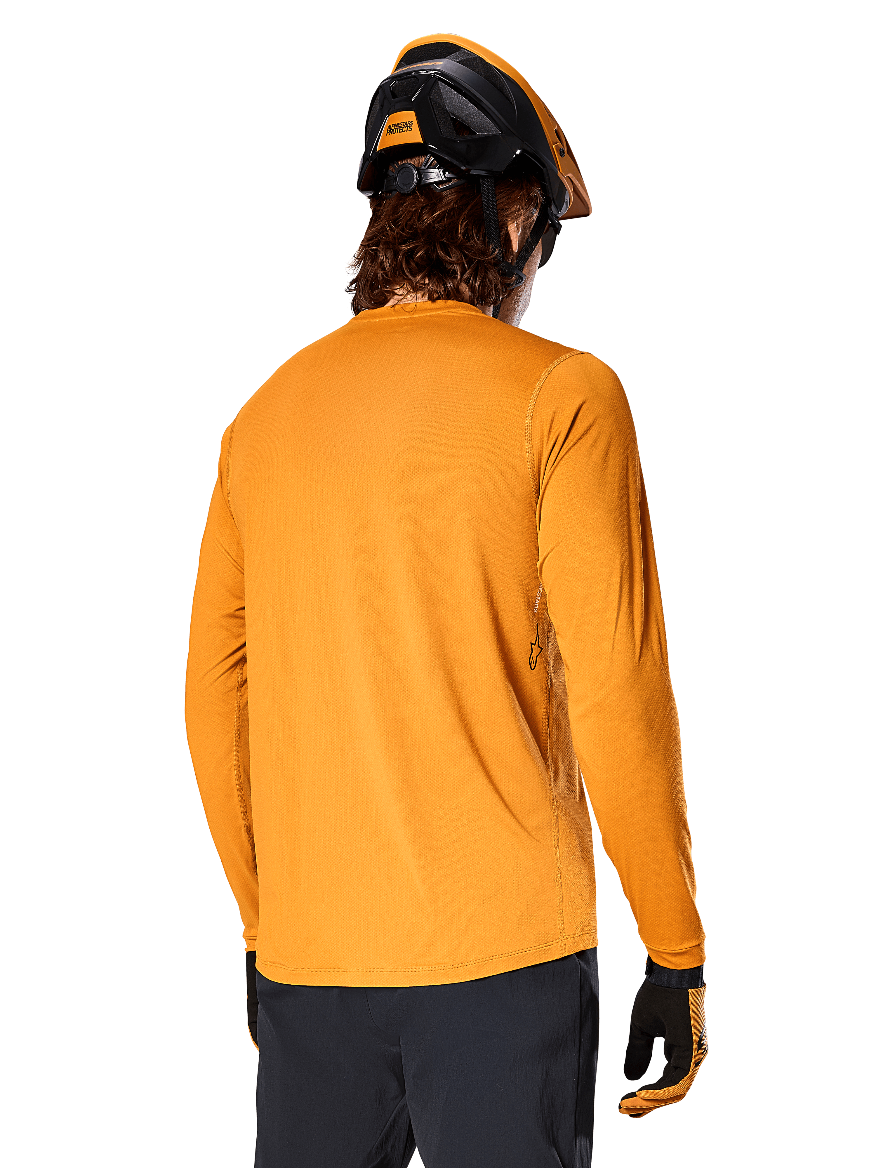 Alpinestars A-Dura Rocker Long Sleeve Jersey, Dark Gold, back view of rider wearing a black and orange MTB helmet, dark pants, and matching gloves, casual performance mountain bike apparel