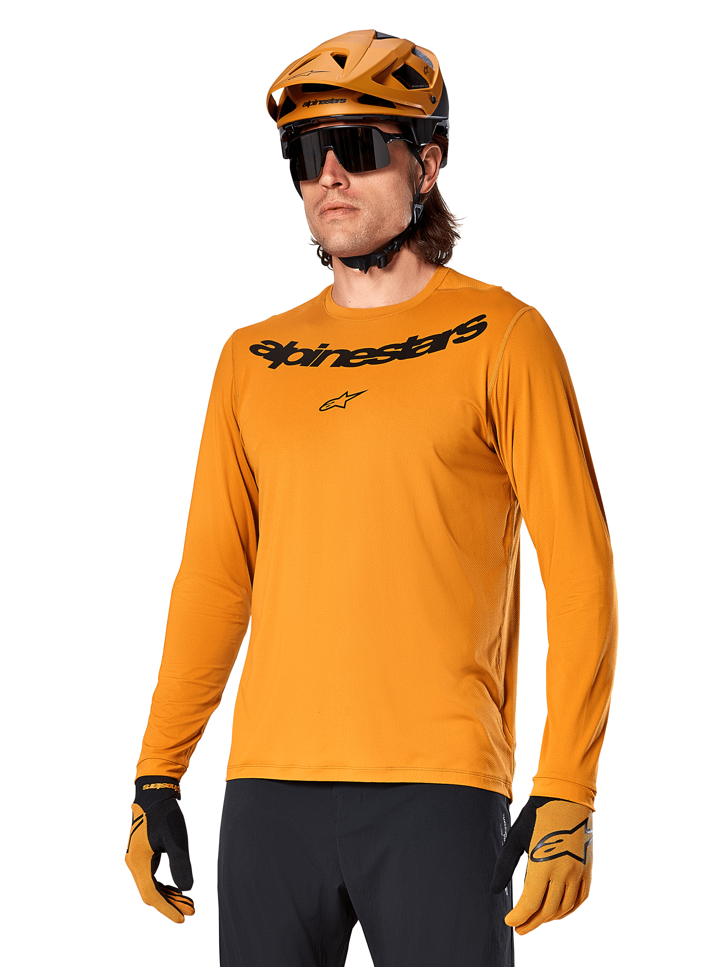 Alpinestars A-Dura Rocker langærmet trøje, MTB-mountainbike-trøje, mørkeguld, person iført trøje med matchende hjelm og handsker, sportsligt koordineret look med Alpinestars-navnetræk på brystet