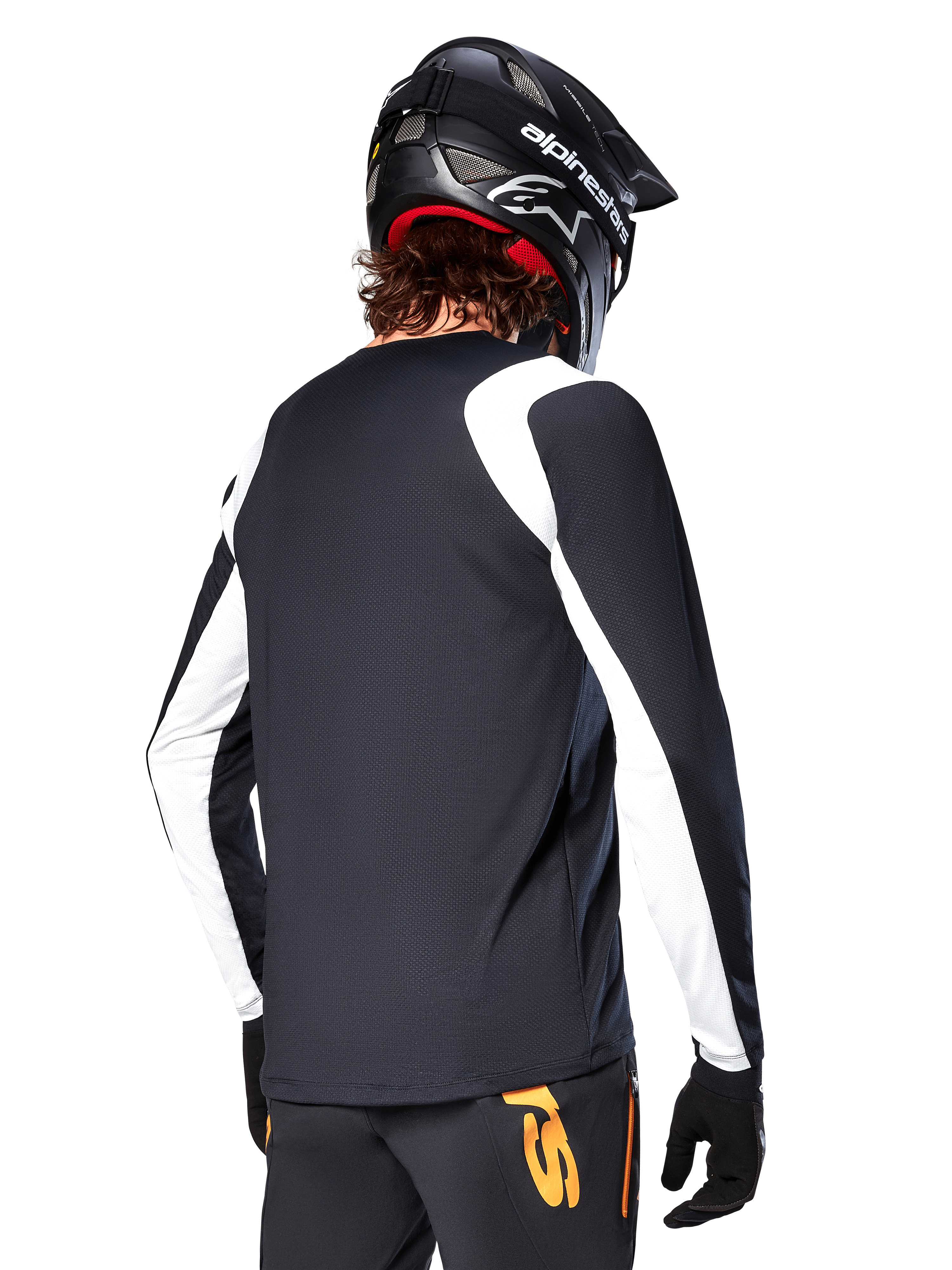 MTB-rytter iført Alpinestars A-Supra Oscar langærmet trøje, sort med hvide paneler på skuldre og ærmer, set bagfra, sort hjelm og handsker, bukser med orange detaljer, holdbart off-road cykeltøj