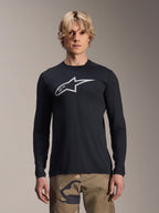 Alpinestars A-Dura Astar langærmet trøje, sort med sølvfarvet Astars-logo på brystet, båret af en model med camouflagebukser, afslappet MTB-performance-beklædning til mountainbike