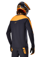 Alpinestars A-Supra Race Jersey - Langærmet, sort og orange, set bagfra af rytter iført matchende hjelm og mountainbike-bukser, performance-pasform med mikroperforeret tekstur, professionelt MTB-racerudstyr